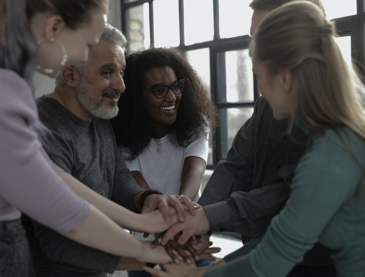 Group of people joining hands together.